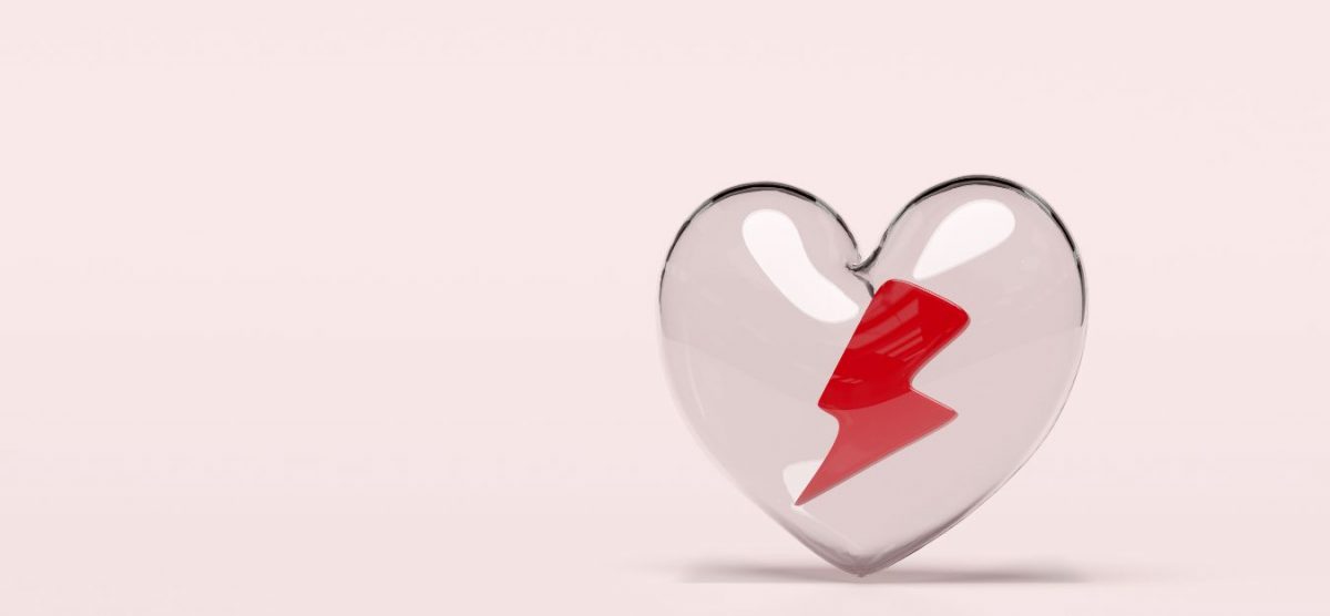 A glass heart with a red lightening bolt inside in, on a light pink background.